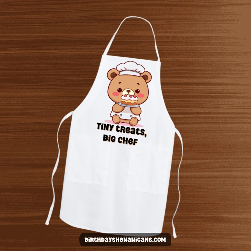 Funny apron with a kawaii bear chef presenting a comically tiny cake, ideal for bakers who enjoy a humorous and cute kitchen style.