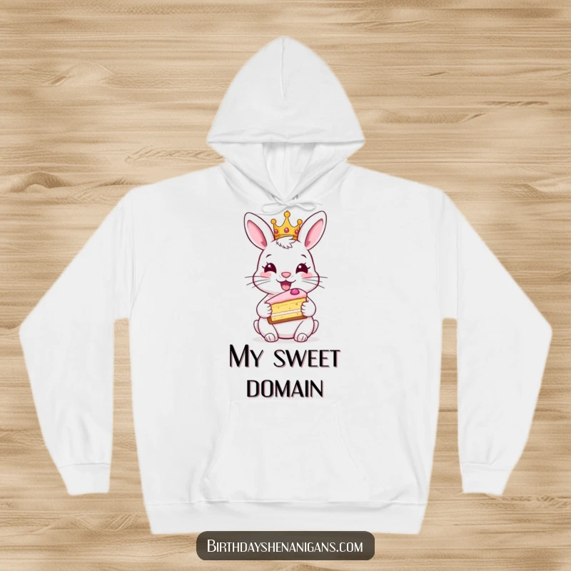 Funny rabbit hoodie, cozy, wearing crown, holding cake, royal comfort, warm celebration wear, humorous.