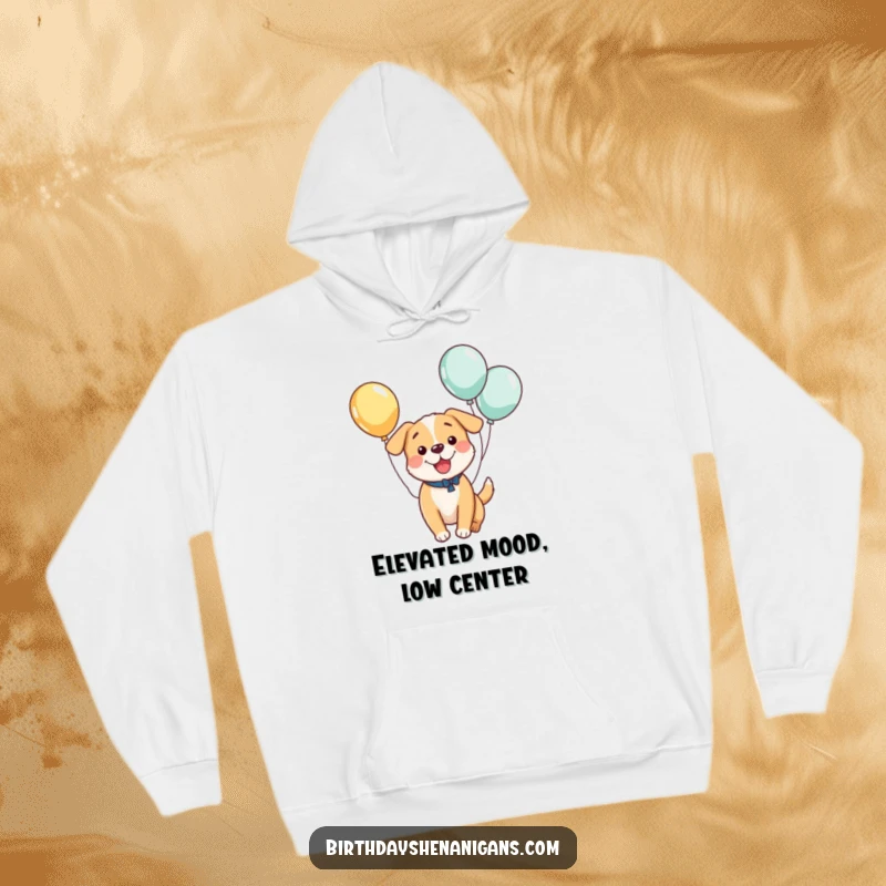 Funny hoodie depicting a kawaii dog gleefully bouncing with balloons tied to its tail, offering cozy humor and a great funny gift.