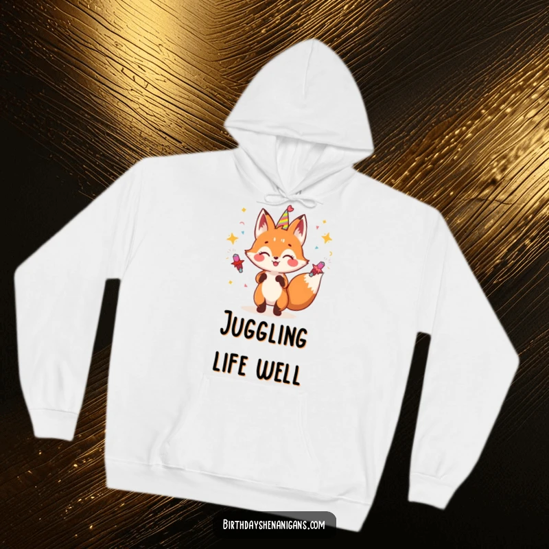 Funny fox hoodie showing a joyful fox character juggling a cascade of party poppers, radiating pure excitement.