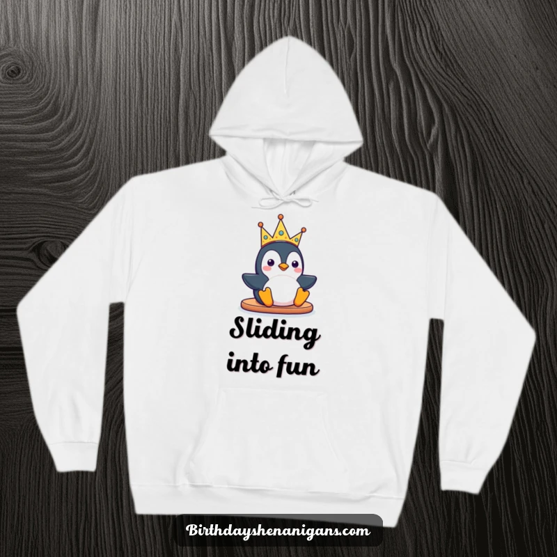 Funny kawaii penguin character sliding with a silly party crown on a cozy hoodie, offering warmth and a festive, playful spirit.