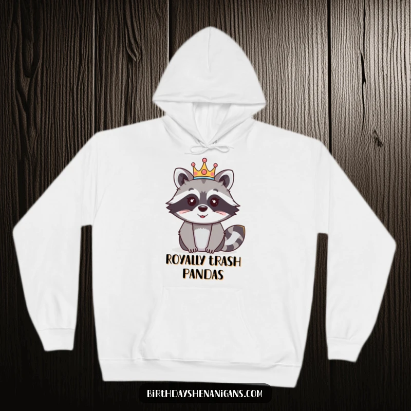 Funny raccoon hoodie showing a happy raccoon character adorned with a festive crown, radiating royal glee.