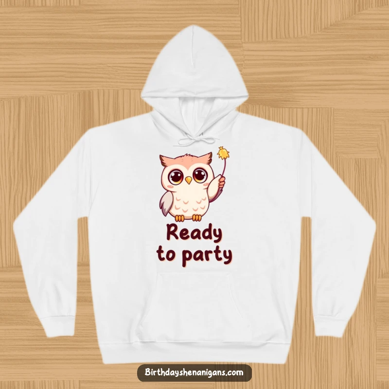 Funny Kawaii owl with wide, expressive eyes, its wing reaching for a colorful streamer, cozy hoodie design for warmth and fun.