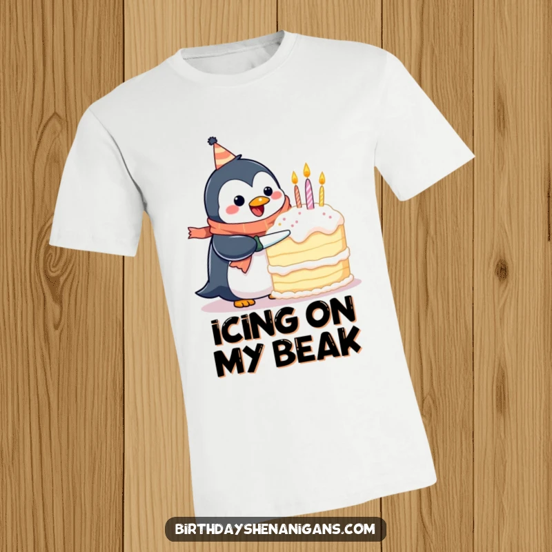 Funny t-shirt showing a happy penguin wearing a birthday scarf, struggling to cut an enormous cake, a symbol of festive ambition.