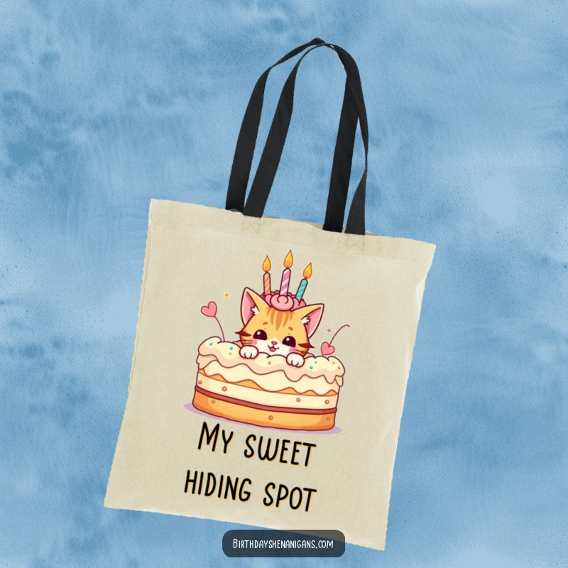 Funny tote bag designed with a playful cat character peeking from a giant birthday cake, perfect for carrying essentials.
