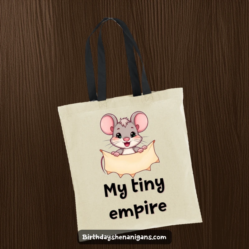 Funny tote bag illustrating a persistent mouse character actively hanging a festive banner, signifying effort and achievement.